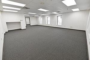 One City Centre, Suite 313, offers a spacious open floor plan with white walls and grey carpet.