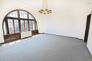 The primary office in this suite has an open floor plan with an arched window.