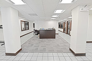 Fountain Square, Suite 030, spacious reception area with large pillars. Multiple office window line the hallways proceeding to the back of the space.