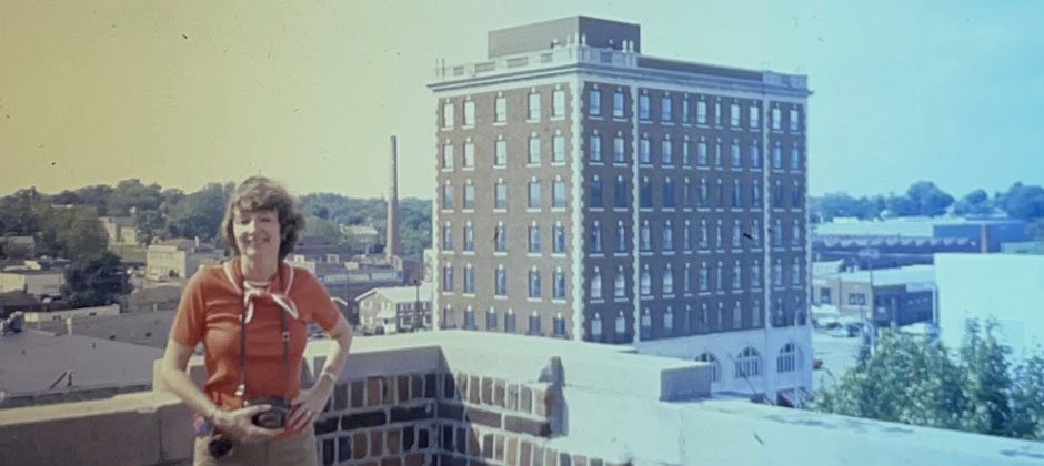 Gayle Cook standing on a balcony with Graham Plaza in the background